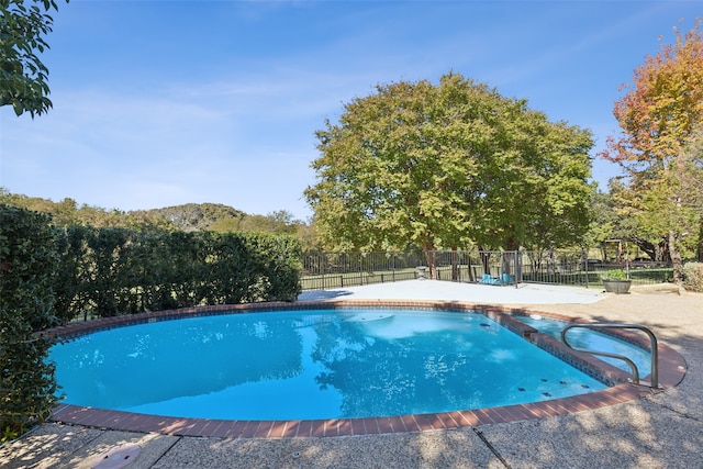 view of pool with a diving board and a patio