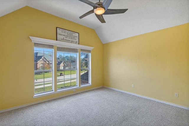 spare room with carpet flooring, ceiling fan, and vaulted ceiling