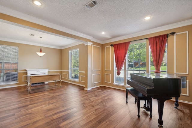 misc room with decorative columns, dark wood-type flooring, and a textured ceiling