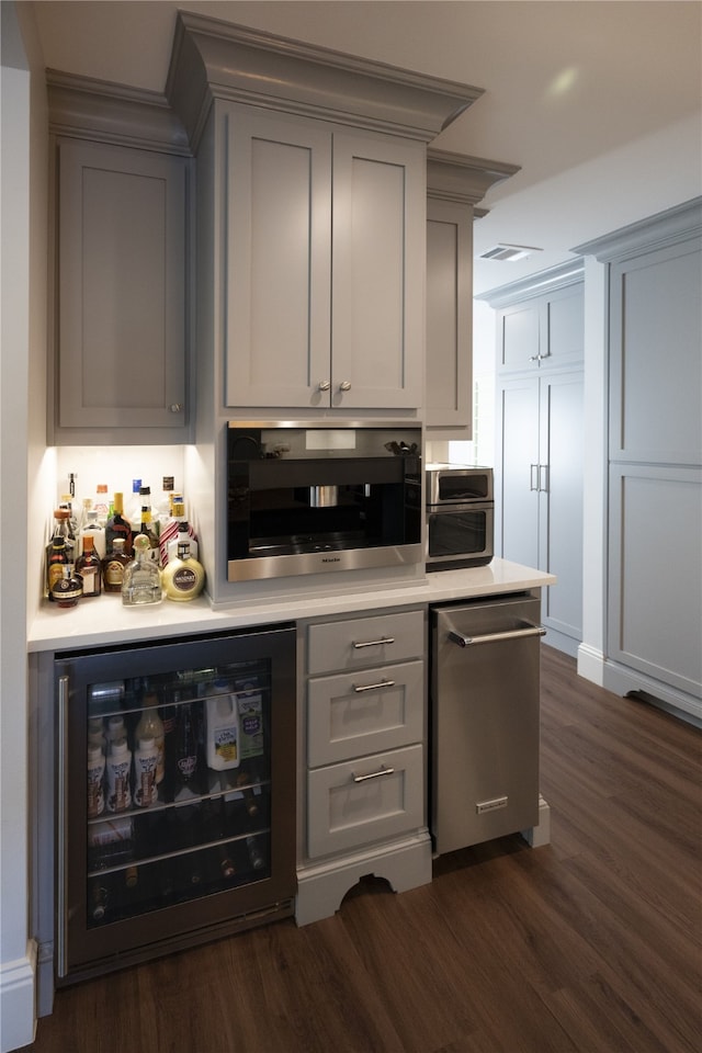 bar with gray cabinetry, dark hardwood / wood-style floors, stainless steel appliances, and wine cooler