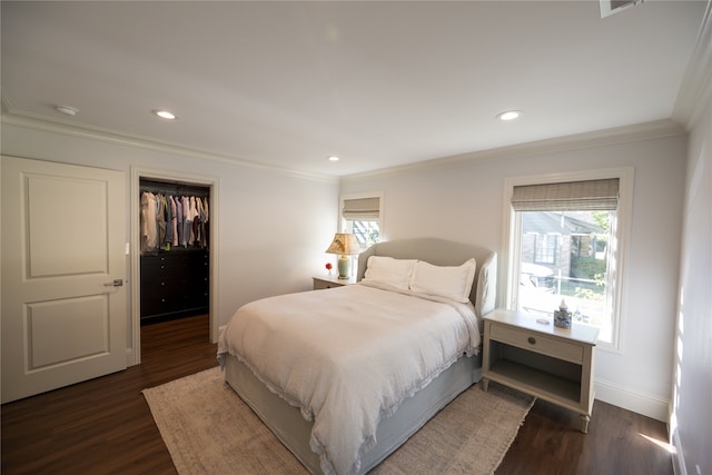 bedroom with dark hardwood / wood-style flooring, a spacious closet, ornamental molding, and a closet