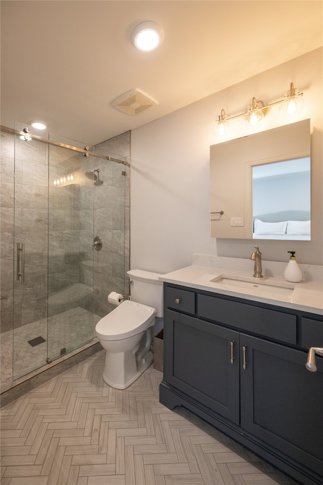 bathroom featuring vanity, toilet, and a shower with door