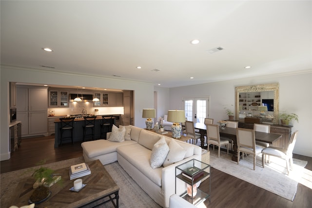 living room featuring dark hardwood / wood-style flooring, crown molding, and french doors