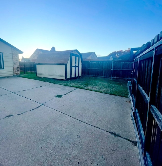 view of side of home featuring a storage shed, a yard, and a patio area