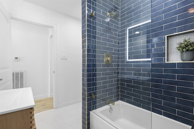 bathroom featuring vanity, wood-type flooring, and tiled shower / bath