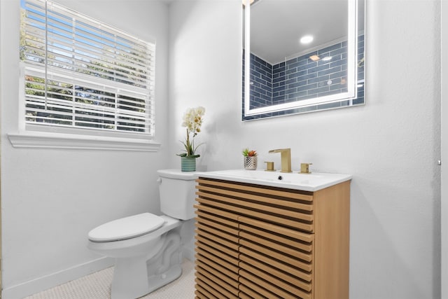 bathroom featuring tile patterned flooring, vanity, and toilet