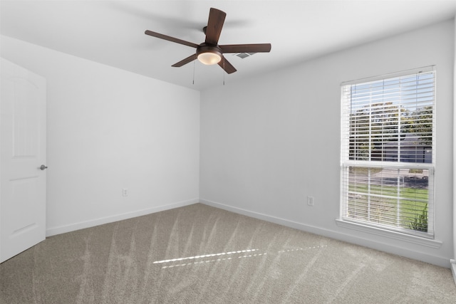 carpeted spare room featuring ceiling fan