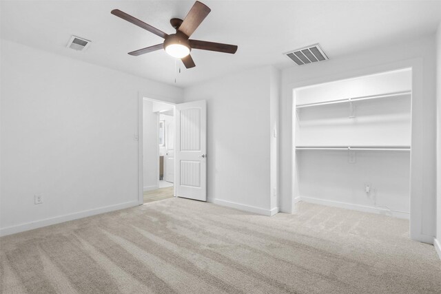 unfurnished bedroom with ceiling fan, a closet, and light carpet