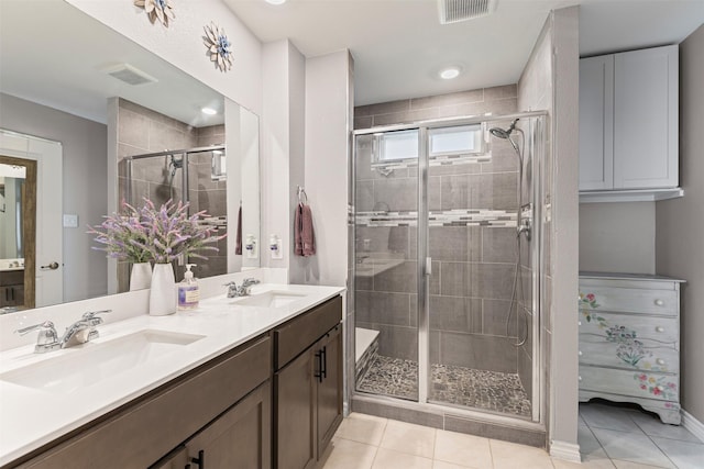 bathroom featuring vanity, tile patterned floors, and a shower with door