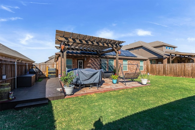 back of property with a pergola, a yard, and a deck