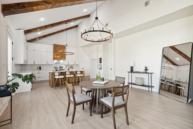 dining space with beamed ceiling, a notable chandelier, high vaulted ceiling, and light hardwood / wood-style flooring