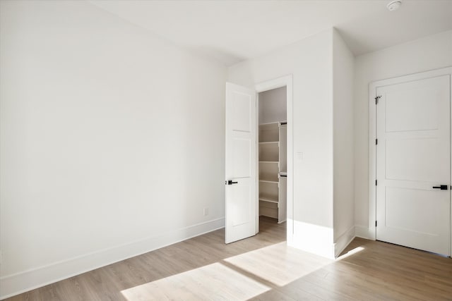 unfurnished bedroom featuring light hardwood / wood-style flooring and a closet