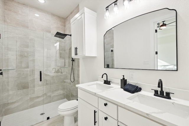 bathroom featuring ceiling fan, vanity, an enclosed shower, and toilet