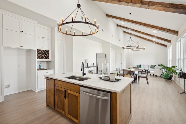 kitchen with pendant lighting, white cabinets, a center island with sink, stainless steel dishwasher, and light stone counters