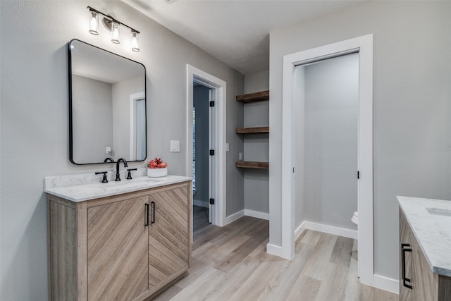 bathroom featuring toilet, vanity, and hardwood / wood-style flooring