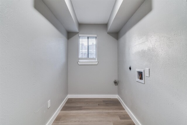 clothes washing area featuring electric dryer hookup, hookup for a washing machine, and light hardwood / wood-style flooring