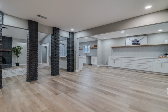 living room featuring ornate columns and light hardwood / wood-style flooring