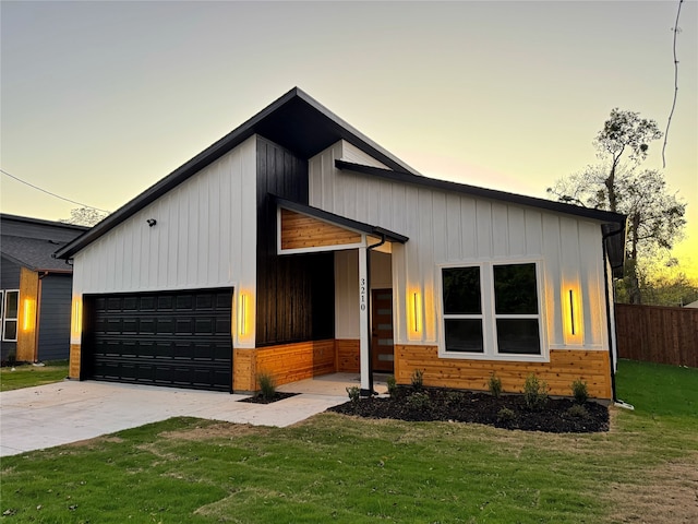 view of front of house featuring a garage and a lawn