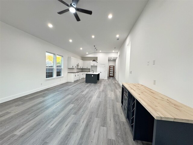 3210 Houston St, Greenville, TX 75401 - unfurnished living room with recessed lighting, lofted ceiling, a ceiling fan, baseboards, and light wood-style flooring