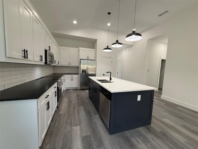 3210 Houston St, Greenville, TX 75401 - kitchen with stainless steel appliances, backsplash, visible vents, a sink, and dark wood-style flooring