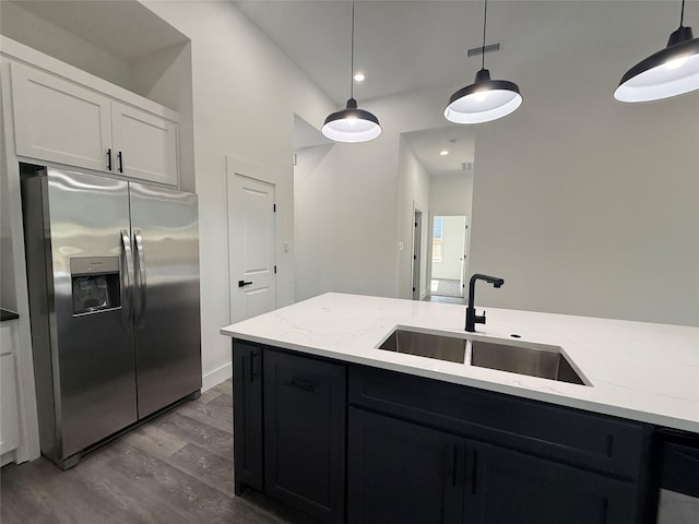 3210 Houston St, Greenville, TX 75401 - kitchen with a sink, stainless steel fridge, visible vents, wood finished floors, and pendant lighting