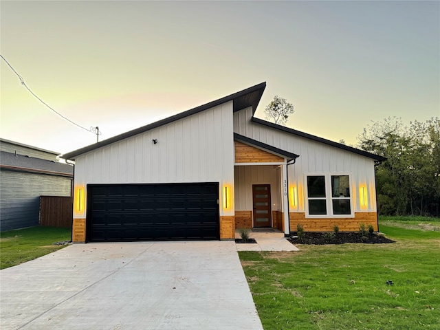 view of front of property featuring a yard and a garage