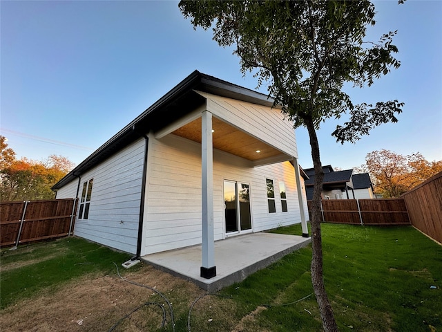 back of property featuring a patio area and a yard