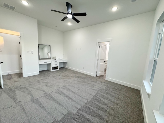 unfurnished bedroom with ceiling fan, carpet floors, and built in desk