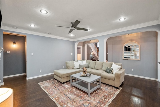 living room featuring dark hardwood / wood-style flooring, ornamental molding, and ceiling fan