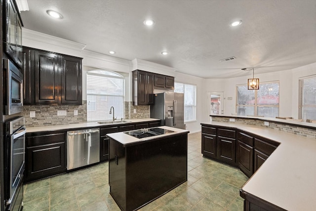 kitchen with sink, a center island, pendant lighting, stainless steel appliances, and decorative backsplash