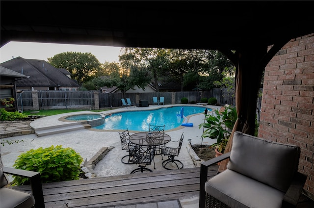 view of pool with an in ground hot tub