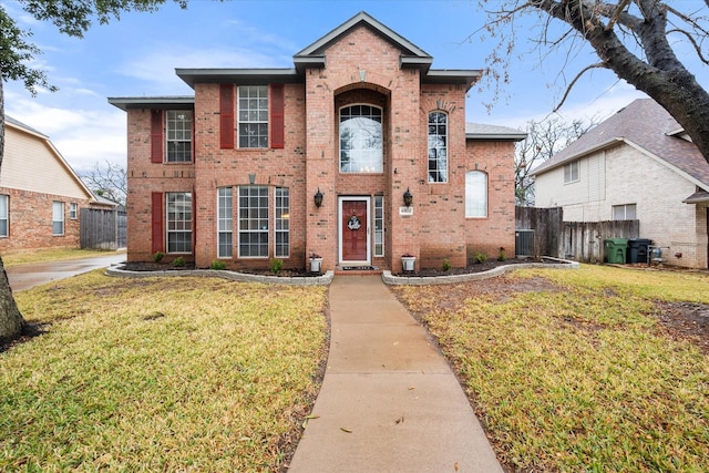 view of front of property with central AC and a front yard