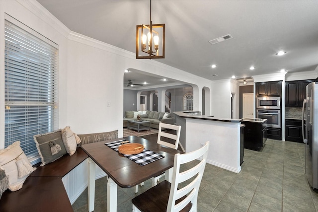 tiled dining area featuring ceiling fan with notable chandelier and ornamental molding