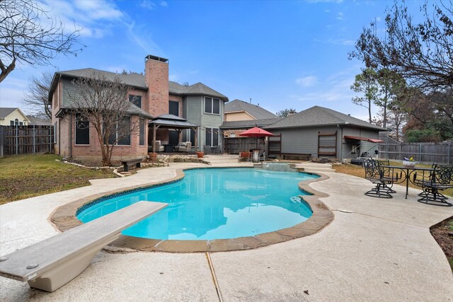 back house at twilight with a swimming pool with hot tub, an outdoor hangout area, and a patio