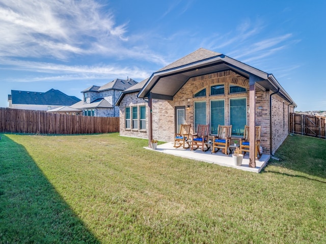 back of house with a lawn and a patio area