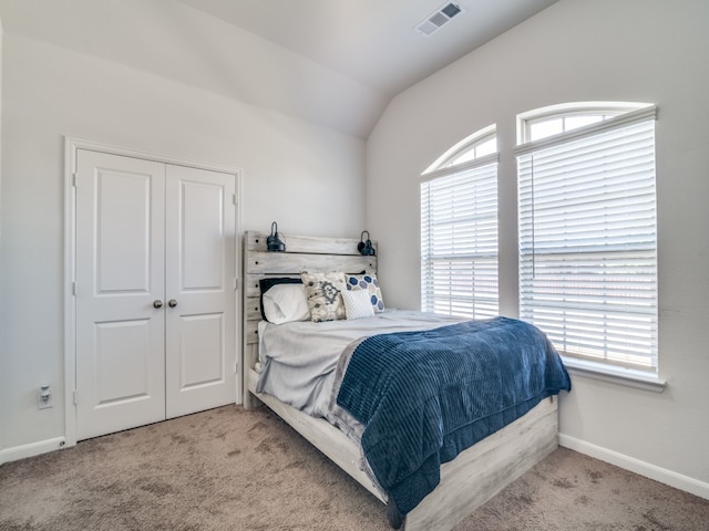 bedroom with multiple windows, vaulted ceiling, and light carpet