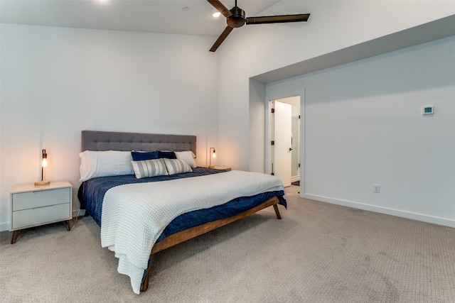 carpeted bedroom featuring ceiling fan, ensuite bathroom, and vaulted ceiling