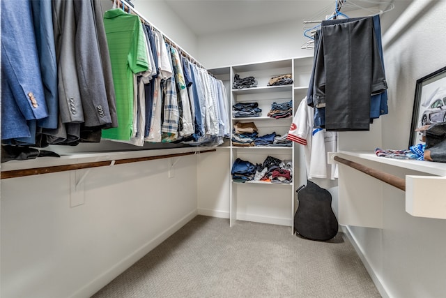 walk in closet with light carpet