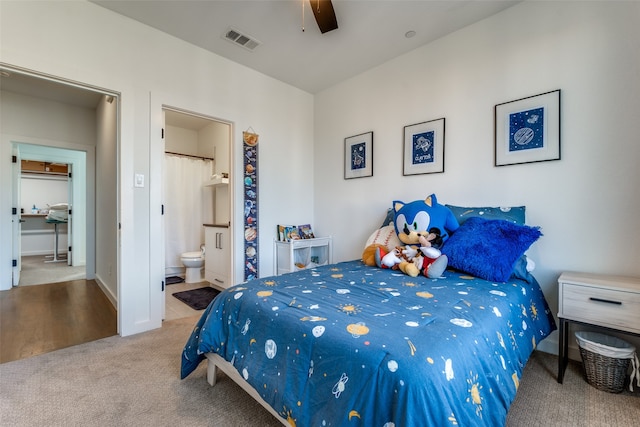 bedroom featuring ensuite bathroom, ceiling fan, and light colored carpet