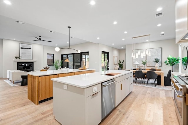 kitchen with white cabinetry, sink, a spacious island, and decorative light fixtures