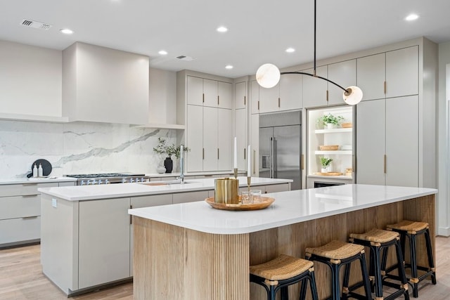 kitchen featuring appliances with stainless steel finishes, backsplash, a large island, and sink