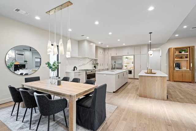 dining space with light hardwood / wood-style flooring and sink