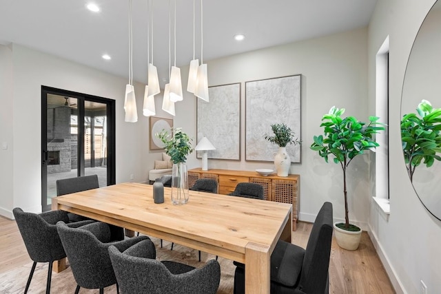 dining area featuring a fireplace and light hardwood / wood-style flooring