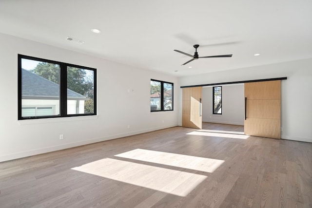 spare room with light hardwood / wood-style flooring, ceiling fan, and a healthy amount of sunlight