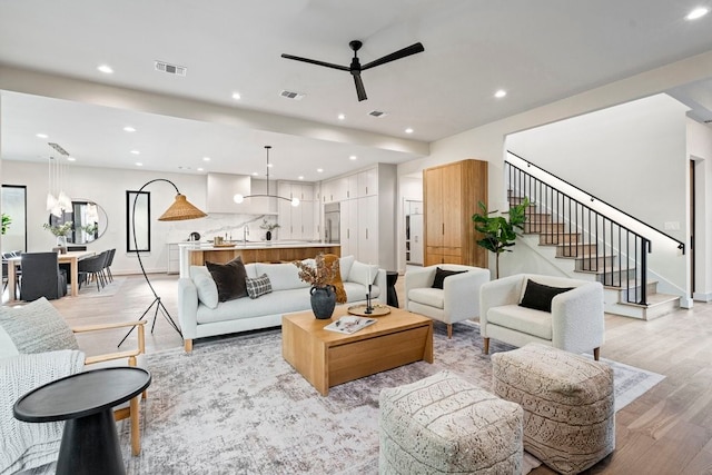 living room with ceiling fan and light hardwood / wood-style floors