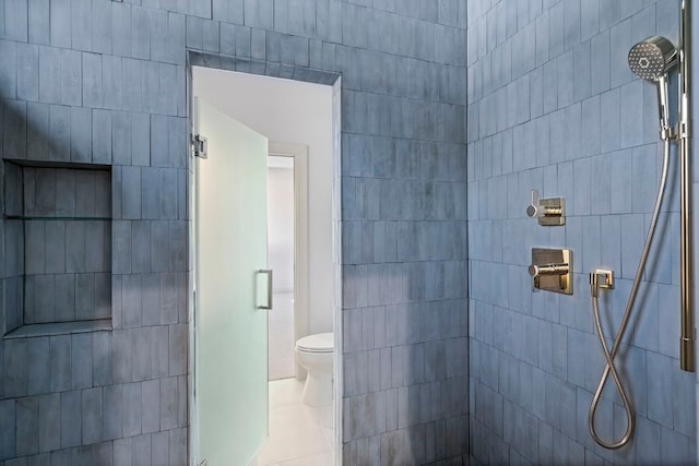 bathroom featuring tile patterned floors, toilet, and an enclosed shower