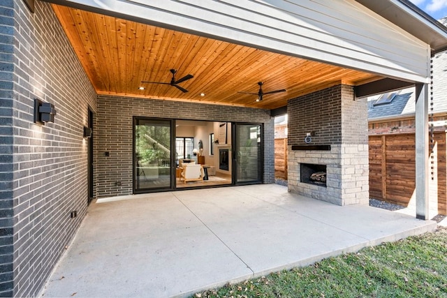 view of patio with ceiling fan and an outdoor stone fireplace