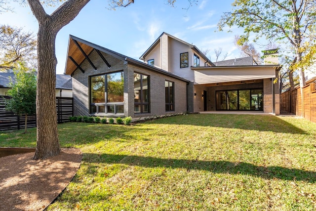 back of house with a yard and a patio