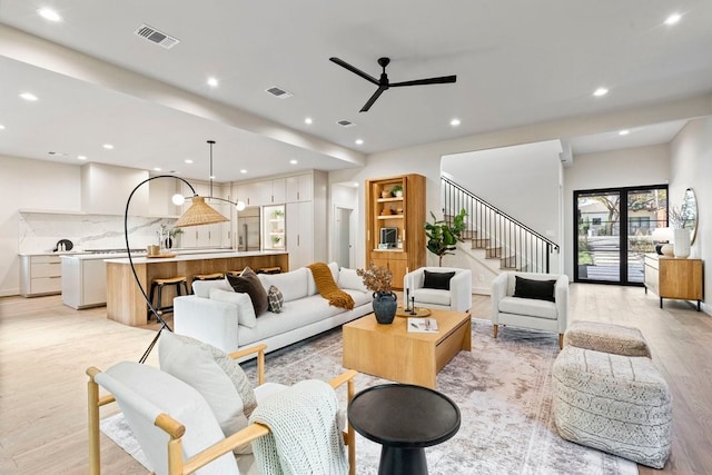 living room with light hardwood / wood-style flooring, plenty of natural light, and ceiling fan