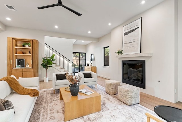 living room with ceiling fan and light wood-type flooring